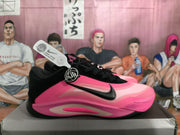 Side profile of the pink and black Nike basketball sneaker with visible swoosh branding.