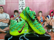 Angled view of the pair highlighting the green uppers, black-and-pink Swoosh, dark laces, and bright outsoles.