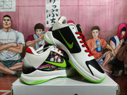 Angled view of the sneakers showing the graphic side panel, black outer side panel, Nike branding, and fluorescent green outsole.