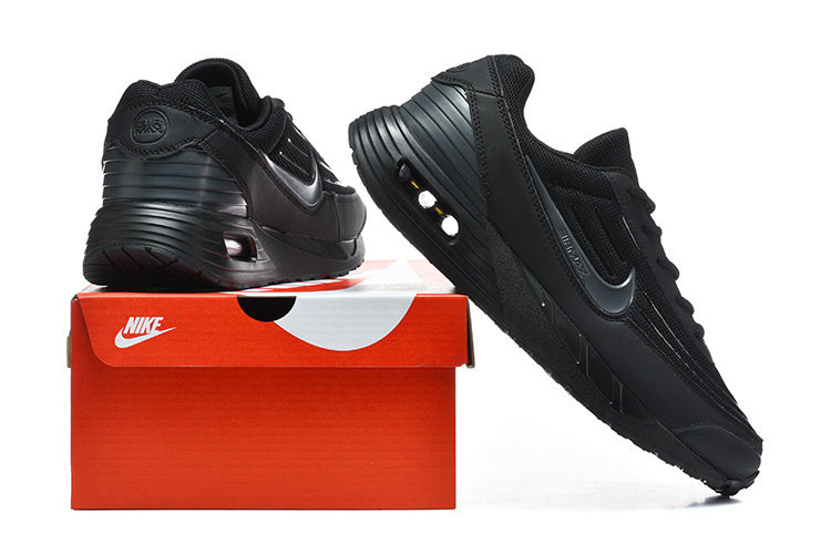 Black Nike Air Max sneakers shown from the side and rear beside a red shoe box.