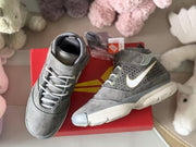 Two gray high-top sneakers shown from above beside a red shoe box, displaying the laces, ankle straps and padded collars.