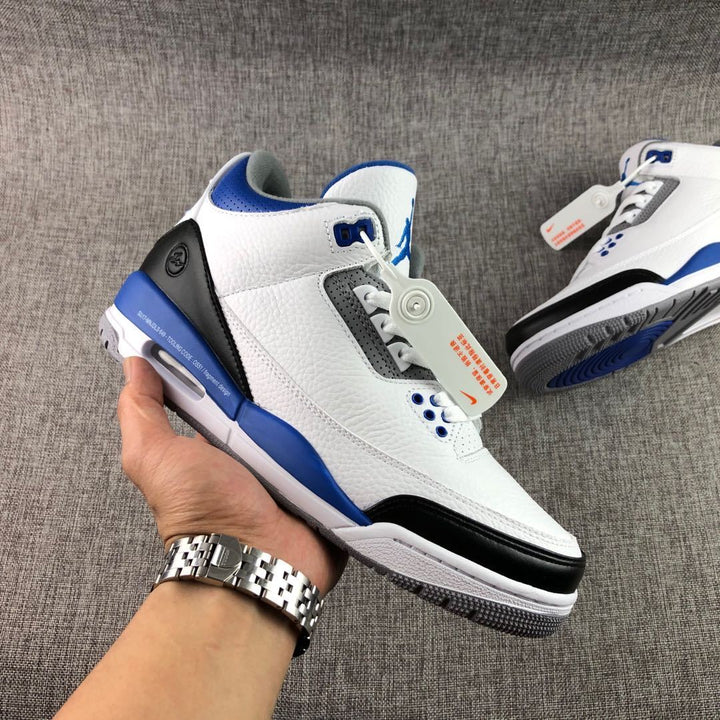 Close-up view of the white, blue, and black high-top sneaker showing the side profile, perforated panels, and lace area.