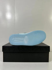 Bottom view showing the translucent light blue outsole and circular traction pattern.