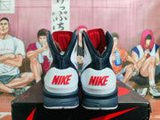 Rear view showing red Nike heel wordmarks on the white and navy shoes
