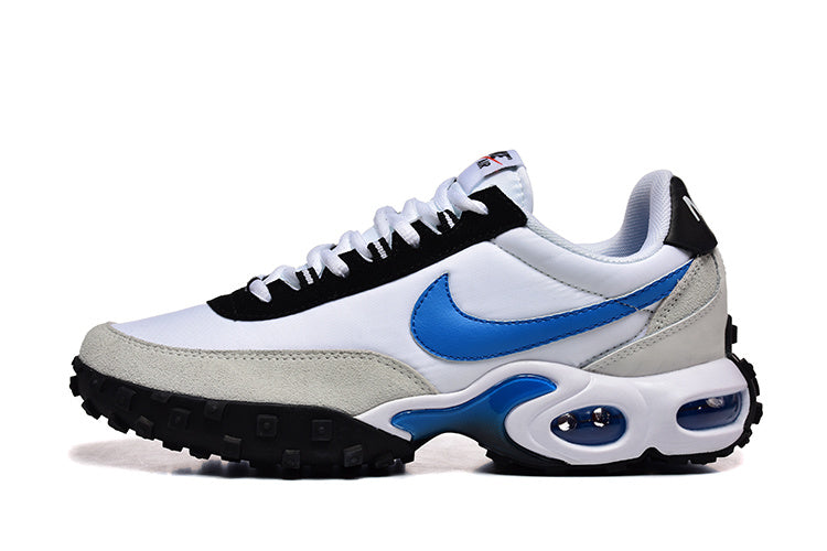 Side view of white and blue Nike Air Max Plus sneakers with gray overlays, black trim, and a sculpted midsole.