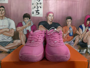Front view of pink Nike basketball sneakers with perforated toe panels, laces, and white Nike logos.