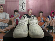 Front view of off-white basketball sneakers with black tongue branding and textured forefoot panels.