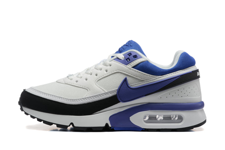 Side view of a white Nike sneaker with blue and black accents, a side Swoosh, and visible heel air unit.