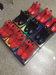 Display of multiple red and black high-top footwear styles on colorful platforms; not a close-up of the featured pair.