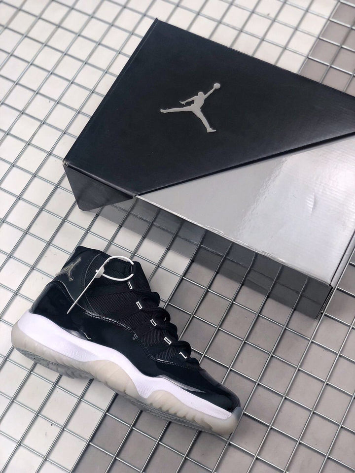 Black high-top sneaker beside a black Jordan-branded shoe box, showing a white midsole and translucent outsole.