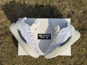 Pair of white Jordan 39 sneakers displayed on a box outdoors