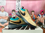 Angled view of beige and turquoise low-top sneakers with black Swoosh logos and orange trim