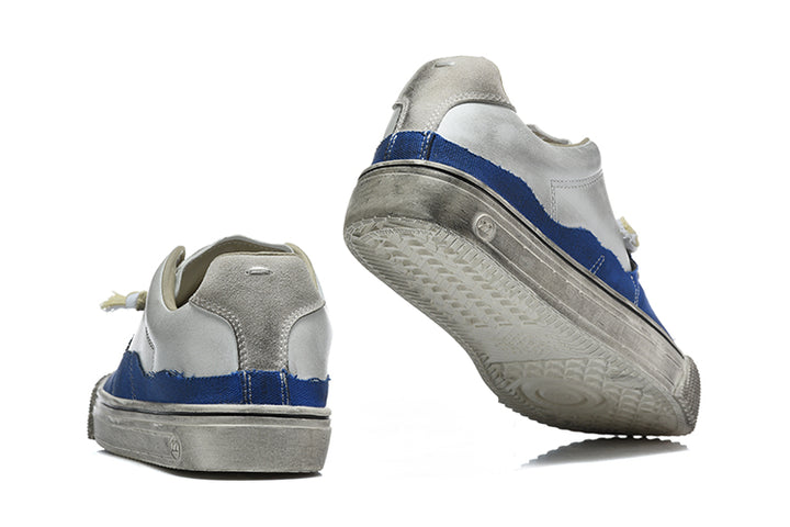 Blue and light grey low-top sneakers shown from the heel and outsole.