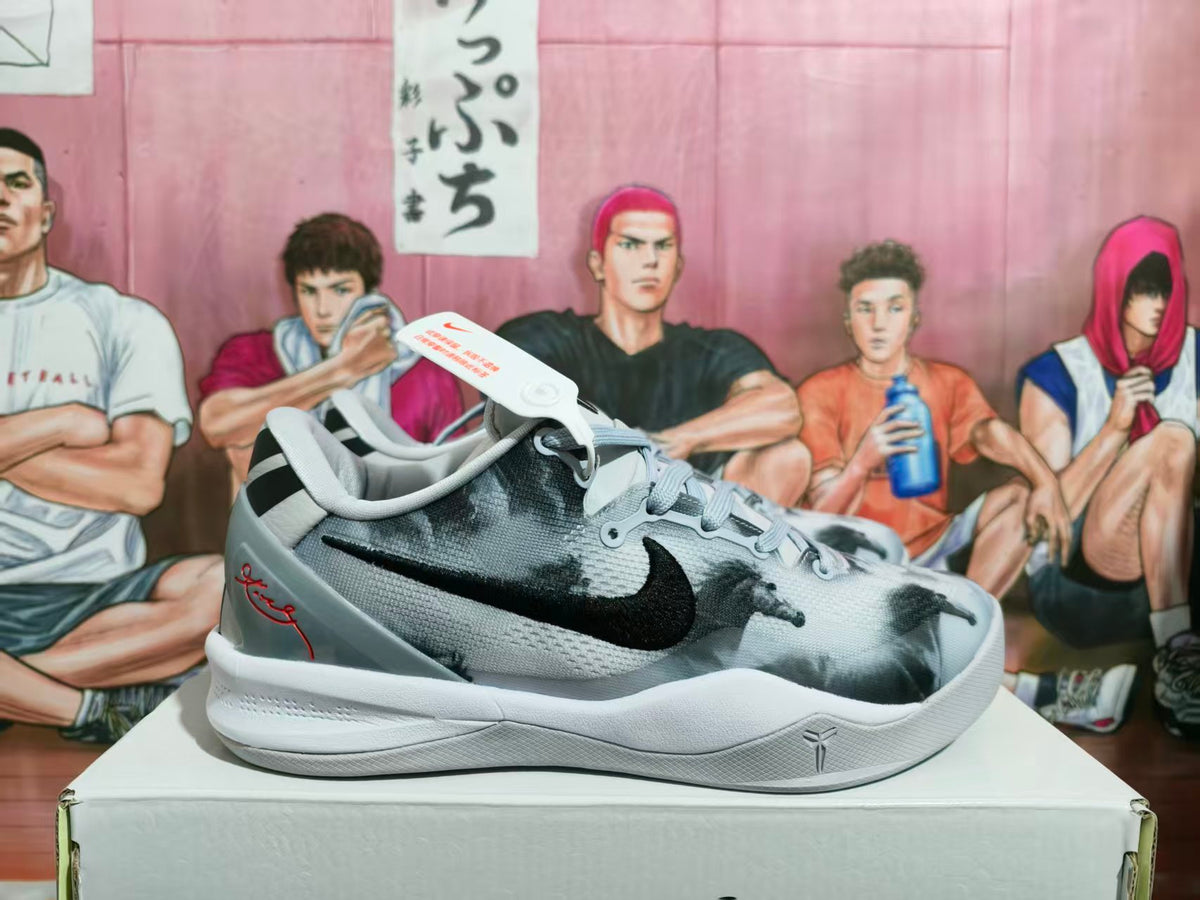 Side view of grey and black Nike basketball sneakers displayed on a box.