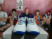 Front view of white basketball shoes with blue tongues, laces, and outsole.