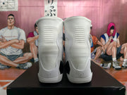 Rear view of white high-top basketball shoes showing heel details and dark contrast panels