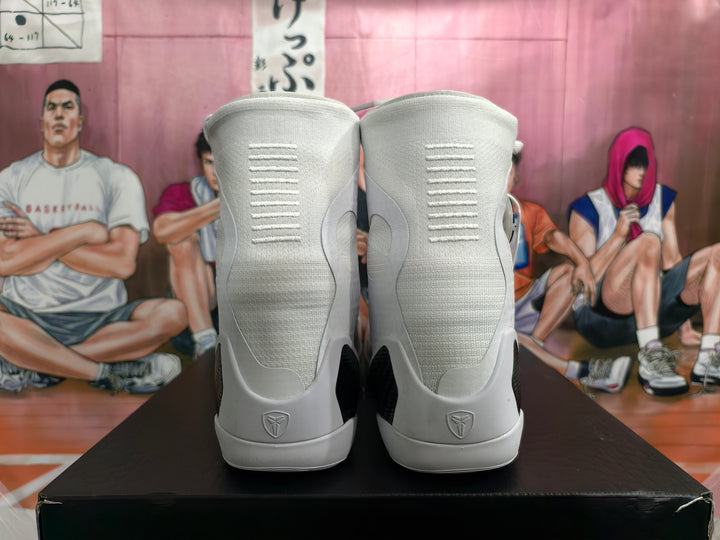 Rear view of white high-top basketball shoes showing heel details and dark contrast panels