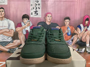 Front view of a pair of green sneakers showing the laces, stitched toe panels, and gum-colored soles.