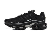 Side profile of black Nike Air Max Plus sneakers with a white Swoosh and visible cushioning units.