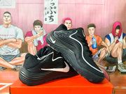 Side view of black Nike basketball sneakers with white Swoosh accents and sculpted soles