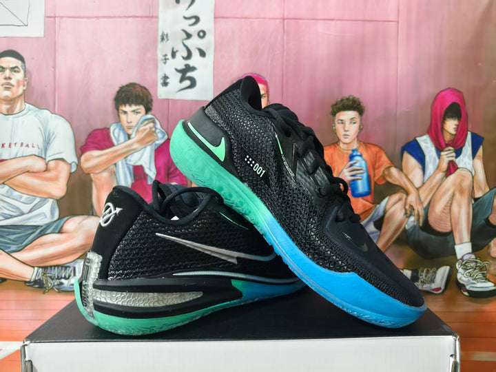 Pair of black Nike basketball shoes with silver swooshes and blue and mint outsoles, shown from the side.