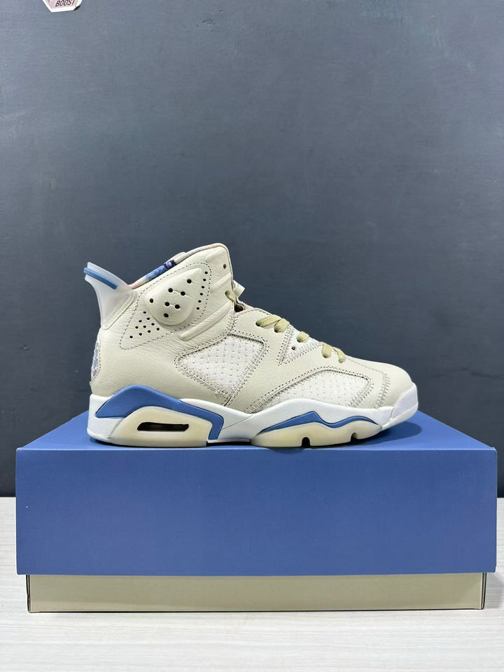 Side view of a cream and blue Jordan Air Jordan 6 Retro Sashiko sneaker on a blue shoebox.
