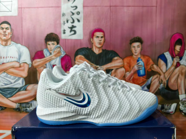 White Nike basketball shoe with layered metallic and blue side Swoosh details and a light blue outsole.