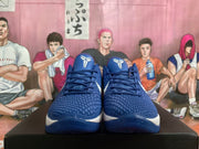 Front view of a pair of blue Nike Kobe basketball shoes showing textured uppers and white tongue logos.