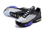 Angled top view of Nike Air Max Plus 3 sneakers with grey panels and blue accents.