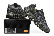 Side view of the patterned sneakers beside a box labeled Air Max 98; the box label shows sample size information.
