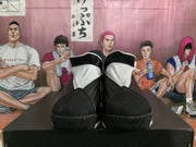 Front view of black and white Jordan high-top sneakers showing layered uppers and textured toe outsoles.