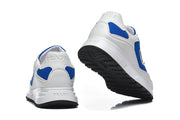 Rear view and outsole view of a white and blue sneaker pair.