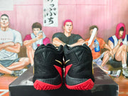 Rear view of the black basketball shoes showing red outsole sections.
