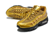 Angled top view of the gold-tone Nike Air Max 95 TT pair, showing the mesh and lace details.