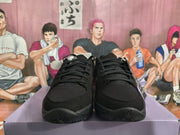 Front view of the black sneaker pair showing black laces, textured toe panels, and black outsoles.