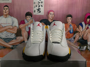 Front view of white Jordan sneakers with red Jumpman tongue logos and yellow side accents