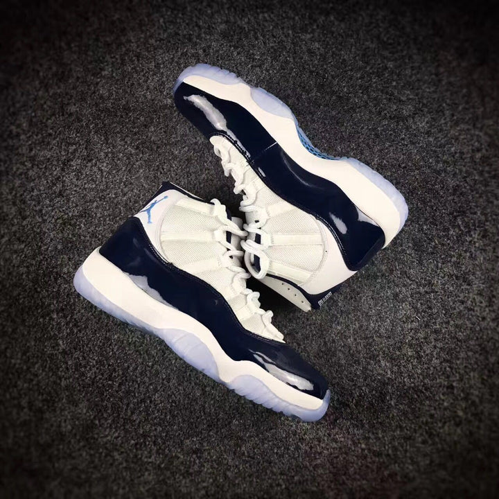 Pair of navy and white Jordan 11 high-top sneakers shown from an angled top view.