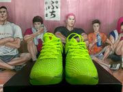 Front view of bright green textured Nike basketball sneakers with neon laces.