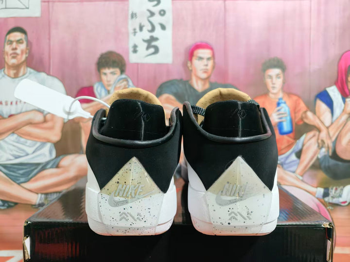Rear view of black and white Jordan Luka 1 shoes with speckled heel panels.