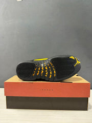 Bottom view of a Jordan Air Jordan 12 Retro sneaker showing the black patterned outsole with yellow accents and a Jumpman mark.