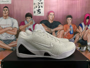 Side view of a white Nike basketball sneaker showing the Swoosh, textured upper, sculpted midsole, and black side insert.