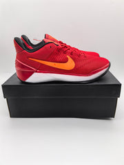 Red Nike basketball sneaker shown in profile on a black box, with an orange Swoosh, white midsole, and black outsole.