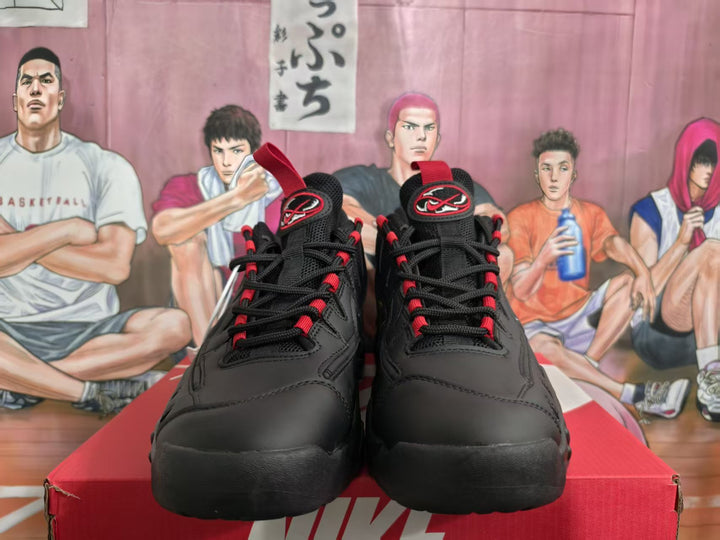Front view of black Nike sneakers with red accents, displayed on a red shoebox.