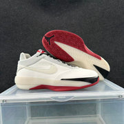 Sole view showing the red patterned outsole, white midsole, and black traction detail.
