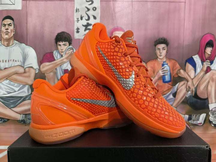 Pair of bright orange Nike Zoom basketball sneakers displayed on a black box, showing the textured upper, silver Swoosh, and sculpted sole.
