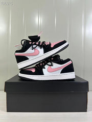 Two black, white, and pink low-top sneakers stacked on a black shoebox, showing the pink side Swooshes and contrasting panels.