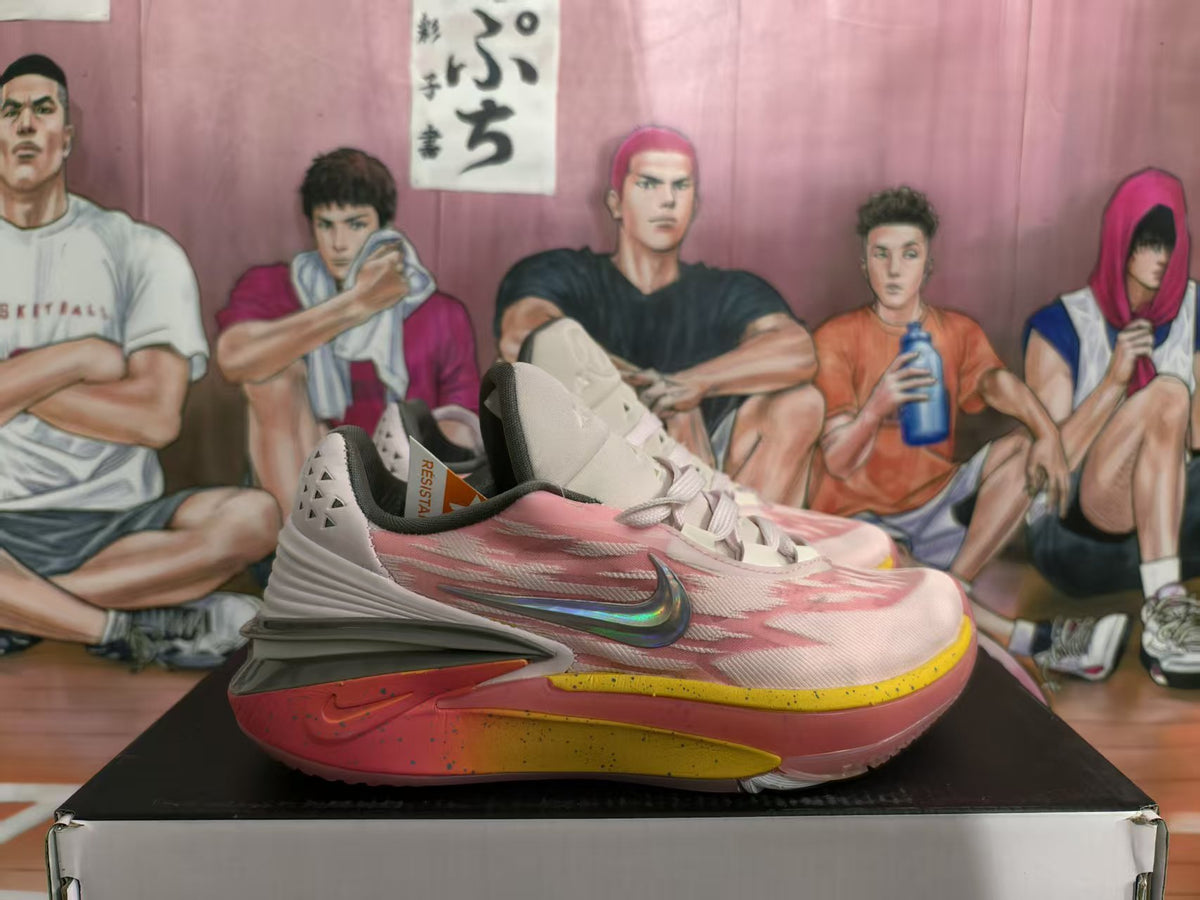 Side view of peach pink and white Nike sneakers with yellow and red-toned sole accents on a box.