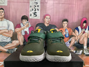 Front view of olive green basketball shoes with yellow accents, laces, and a wide midfoot strap.