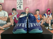 Front view of navy Nike Kobe basketball shoes with white and aqua graphic details