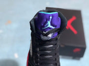 Front view of the sneaker showing black laces, a purple padded tongue, and a turquoise Jumpman logo.